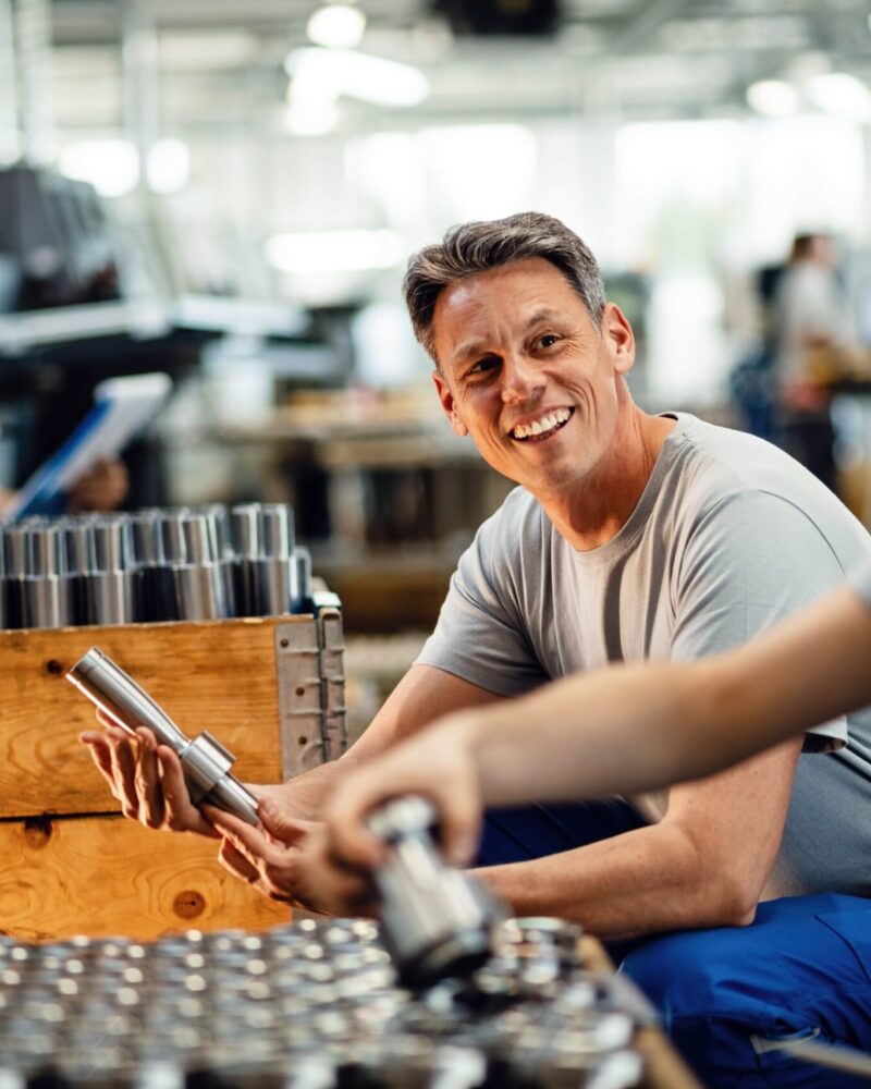 deux-travailleurs-acier-heureux-preparant-produits-fabrication-pour-distribution-communiquant-dans-installation-industrielle-accent-est-mis-travailleur-age-moyen-min